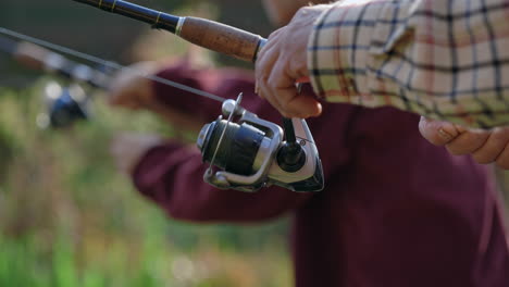 close-up of hands holding fishing rod and reel