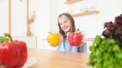 little girl holding red and yellow pepper at home in the kitchen little girl holding red and yellow pepper at home in the kitchen