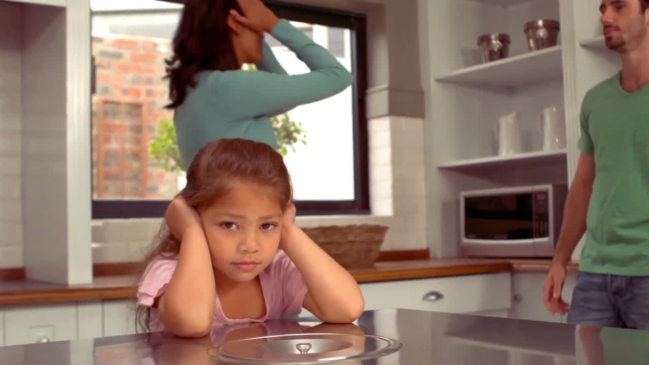 Hispanic couple disputing front of their daughter