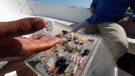 vista de primer plano de ángulo amplio de la guía de pesca explicando y hablando sobre varios tipos de moscas