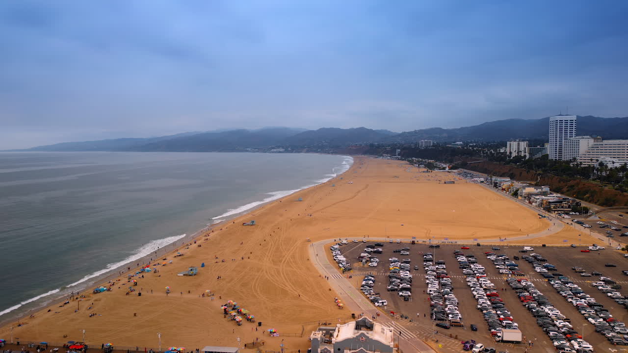 Los Angeles, USA, 29 August 2025: Lots of cars are parked at the parking lot at the beach of the Pacific Ocean. View on the Amusement Pacific Park in Santa Monica, LA, California, USA