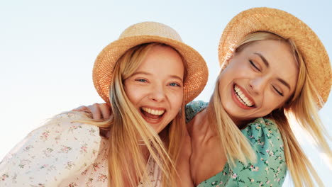 two happy women wearing straw hats