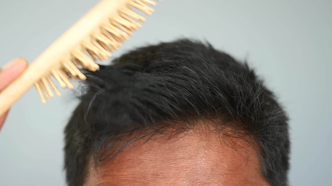 나무 브러쉬 로 머리 를 는 남자