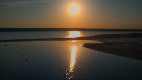 drone playa de mar en el romántico atardecer dorado. pequeñas olas de mar salpicando playa de arena