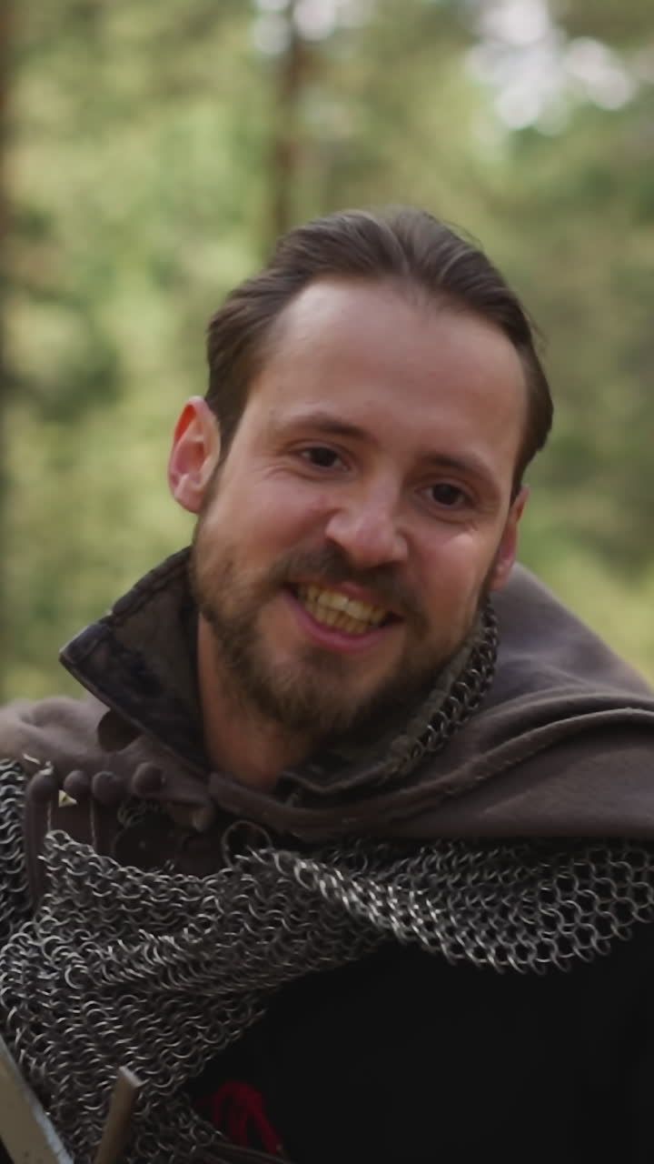 caballero valiente con correa de cadena y espada afilada corre para atacar al ejército de enemigos en el bosque de primer plano en cámara lenta. reconstrucción de la batalla medieval