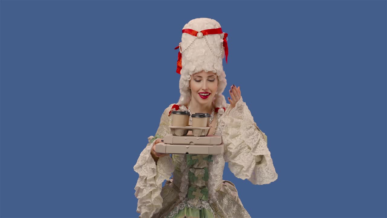 retrato de una dama de la corte con un vestido de encaje vintage blanco y una peluca sosteniendo tazas de café y cajas de pizza. mujer joven posando en el estudio con fondo de pantalla azul. primer plano. cámara lenta lista 59.94fps