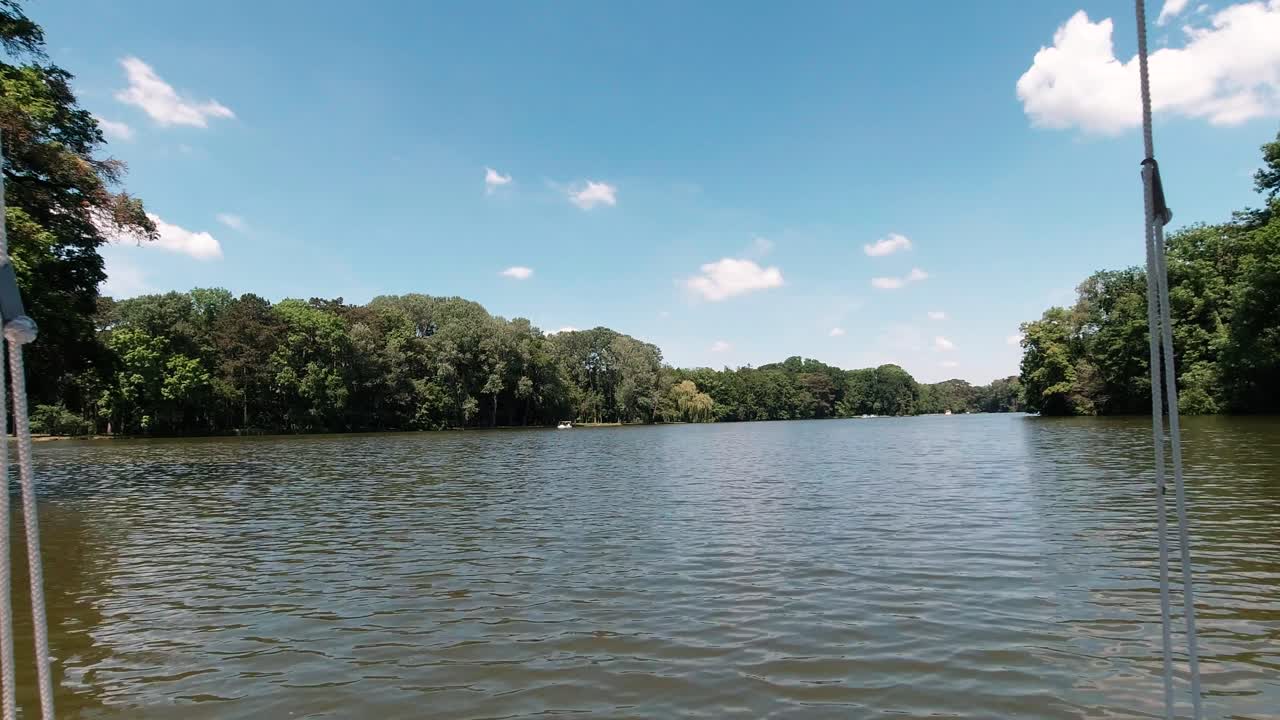 pov paseo en barco por el bosque en el lago con cielo azul y nubes