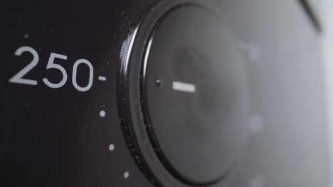 woman presses and turns black round lever to set up oven