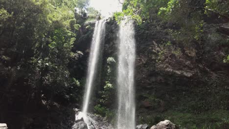 Twin-waterfalls-pouring-over-the-side-of-a-rocky-jungle-cliff