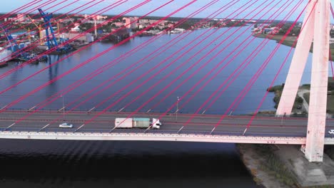 aerial shot of a truck riding on a cable-stayed bridge on a river in gdansk, poland