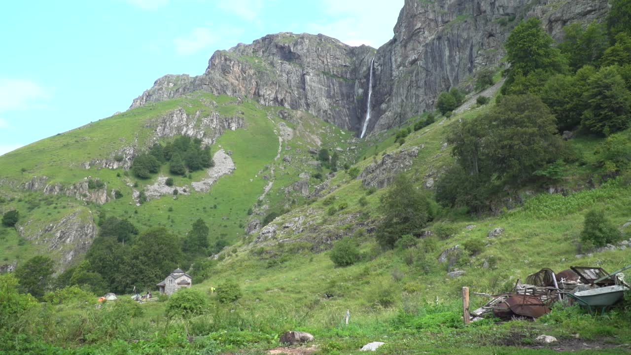Wide shot with a view of the Raisko Praskalo waterfall as seen from Rai hut. The area of ​​Rai hut. At the foot of the waterfall is the Eastern Orthodox chapel of St. Nicholas and St. Panteleimon.