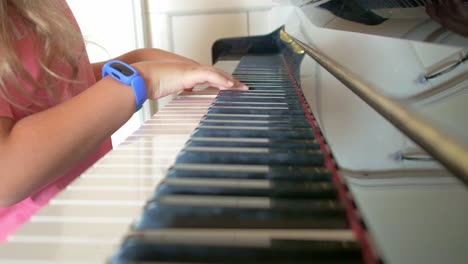 young girl learning to play the piano mid shot arms and hands