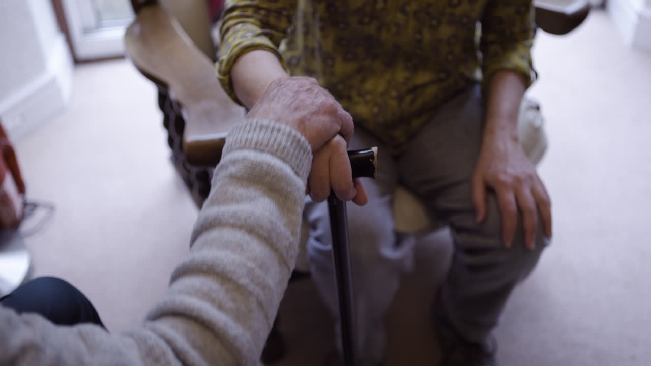 Elderly person with cane getting assistance