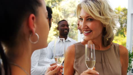 friends interacting with each other while having champagne