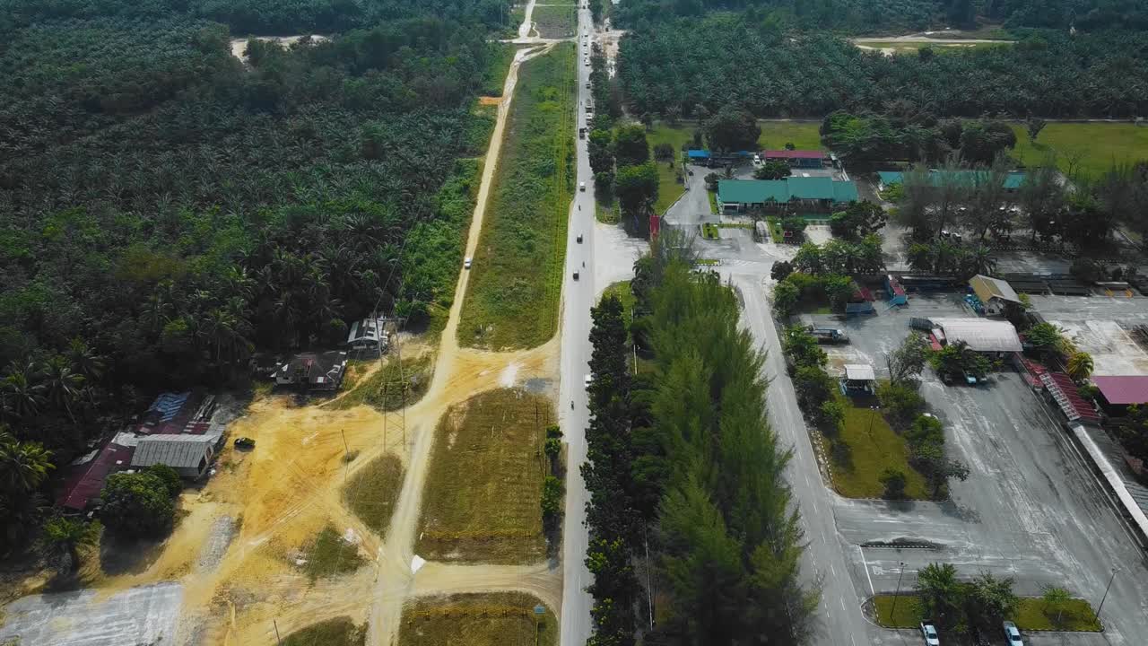 야자유 공장 폐수 거주지의 영화적 드론 영상은 인도네시아에 있는 야자나무 삼림 벌채로 둘러싸인 건물, 주택, 주요 도로 및 인프라로 구성되어 있습니다.