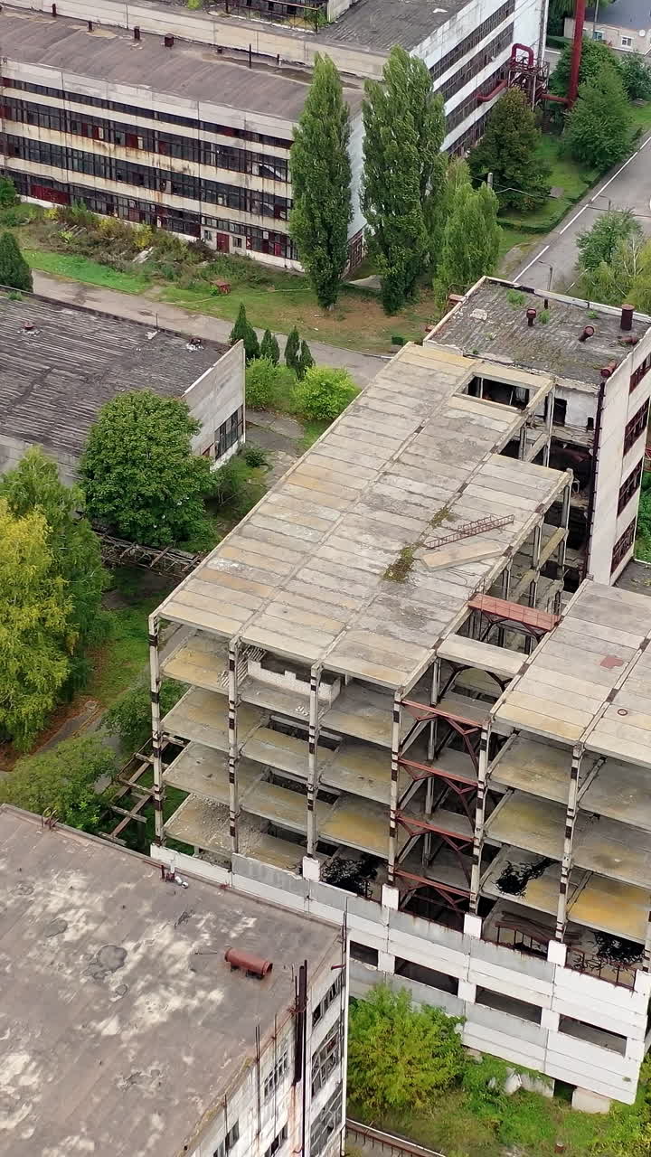 View from above of ruined and abandoned factory. Aerial view of industrial destroyed city buildings. Vertical video