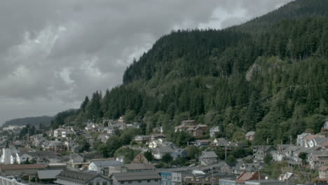 A-large-mountainside-looms-over-an-Alaskan-port-city-as-clouds-slowly-pass-by-overhead