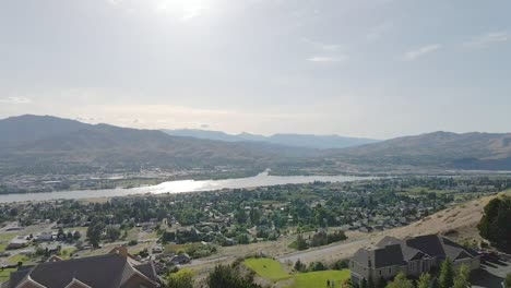 view of different houses surrounded by green trees during sunny day - aerial shot