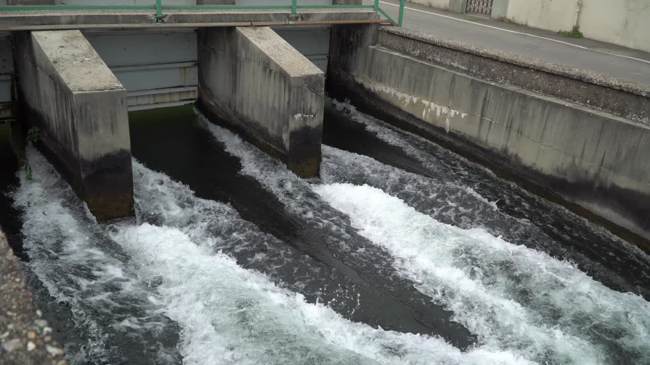 River dam - Flowing and splashing water in cold river.