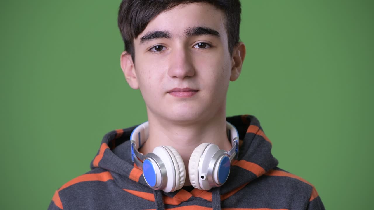 joven y guapo adolescente iraní contra un fondo verde