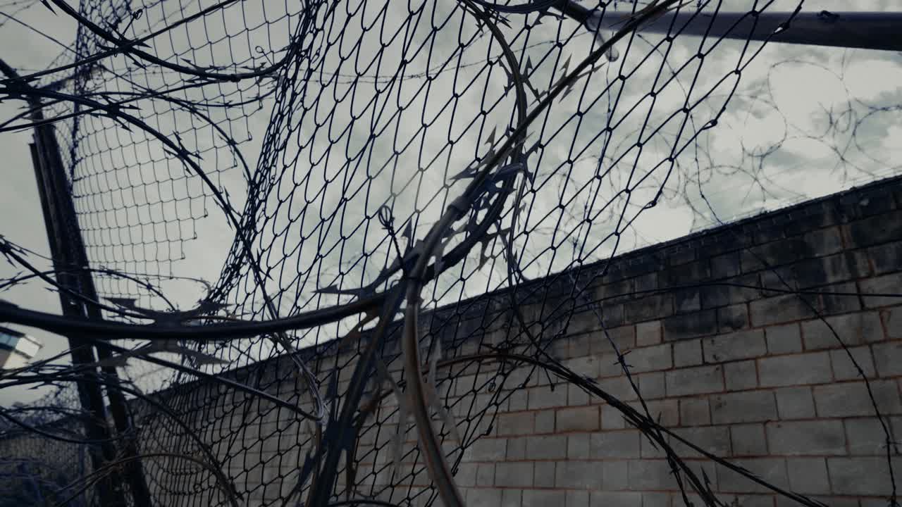 Filo spinato a rasoio e filo spinato su una recinzione di sicurezza contro un cielo nuvoloso