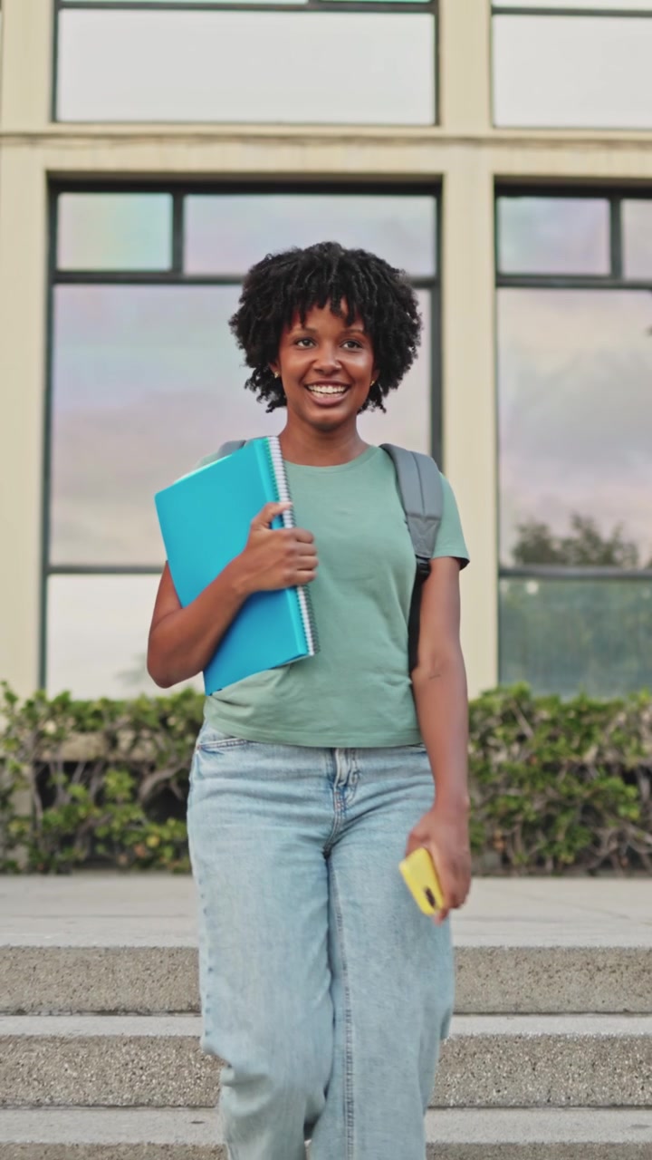 Šťastná mladá afroamerická studentka schází po schodech