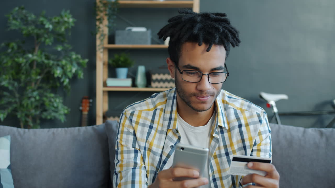 Giovane uomo che usa smartphone e carta di credito