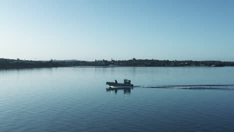 sideways aerial shot of motorboat quickly sailing across ocean