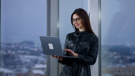 Woman Working on Laptop by Window