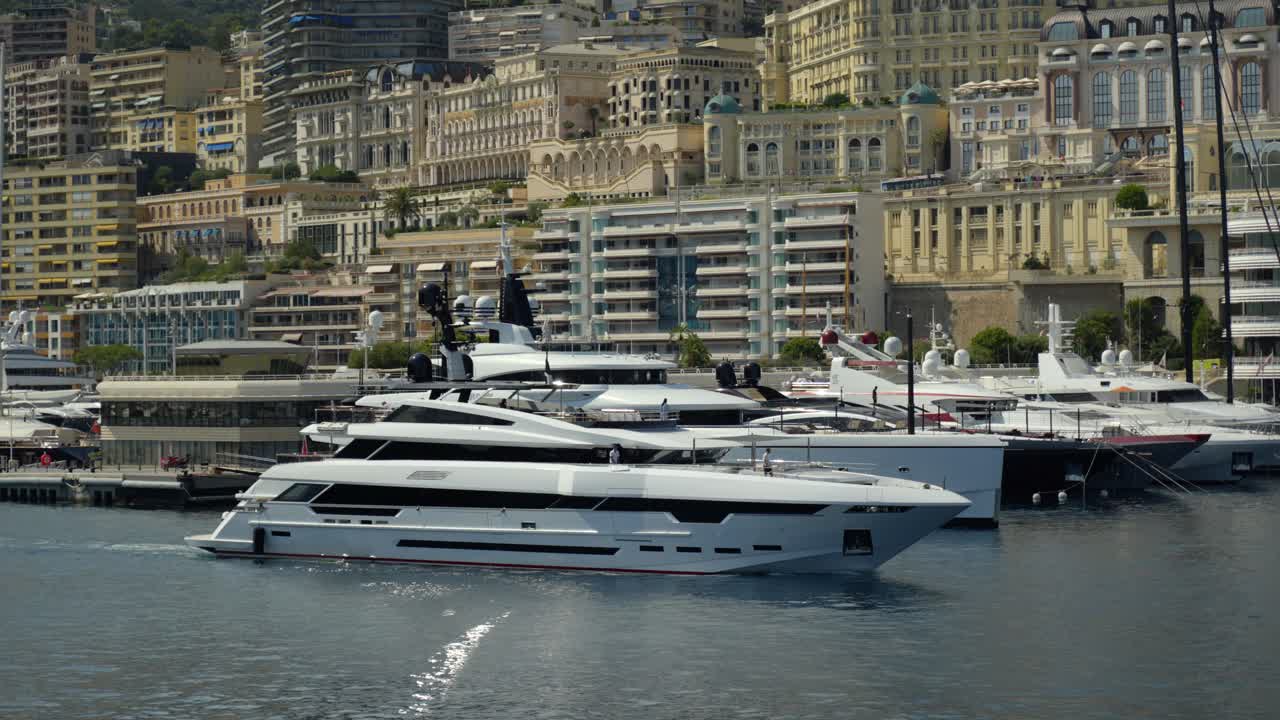 slow panning shot of a private yacht sailing to dock within the Monte Carlo port