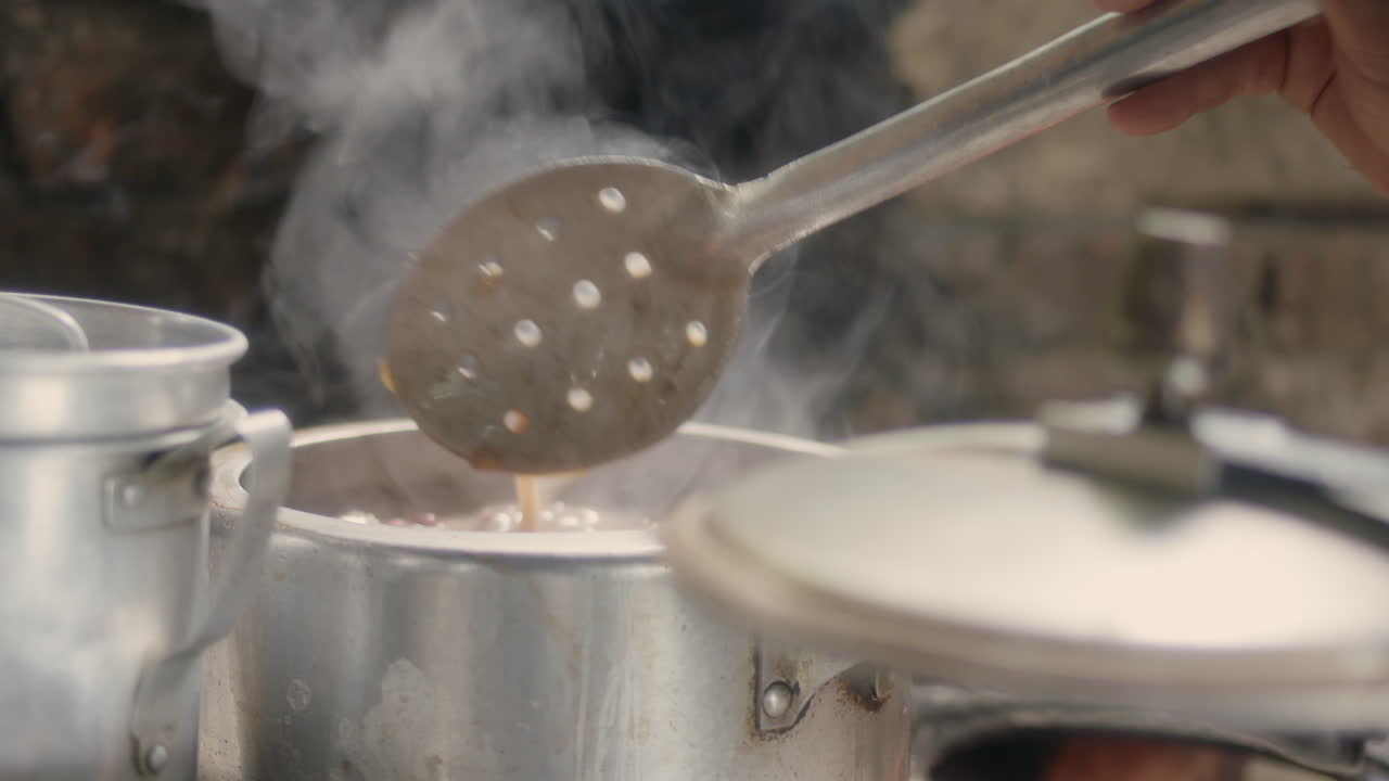 una mujer prepara hábilmente frijoles en una olla para una delicia sabrosa
