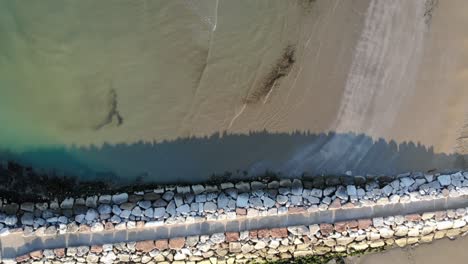 Look-down-aerial-shot-of-empty-beach-with-path-in-Caorle,-Italy