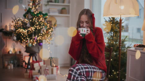 contented woman smelling coffee during christmas at home