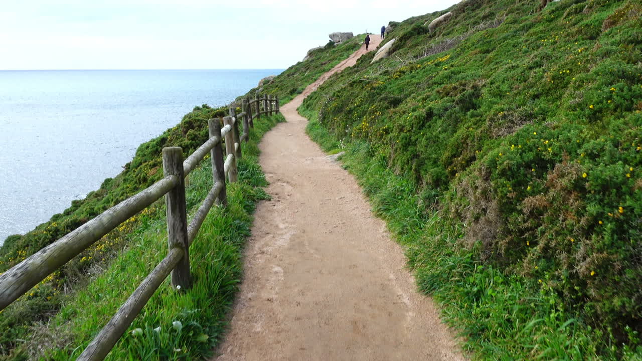 The walking road on the mountain over the Atlantic Ocean. La Coruna, Spain. Shooting in the movement