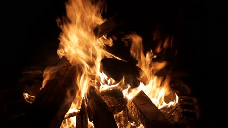 wood fire burning intensely with flames dancing wildly, filmed as medium close up shot