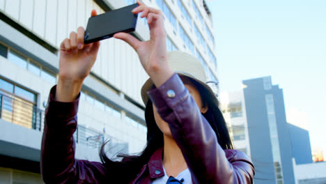 Woman-taking-photo-with-mobile-phone-in-city-street-4k