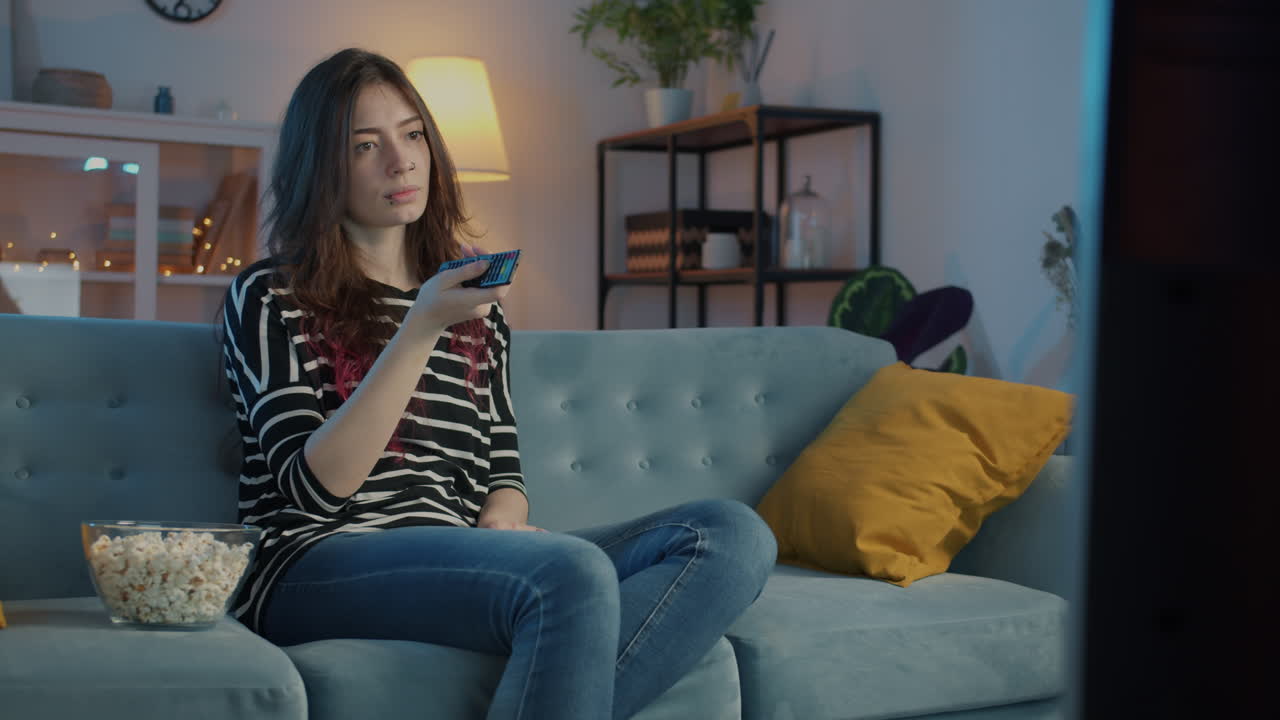 mujer viendo la televisión con palomitas de maíz
