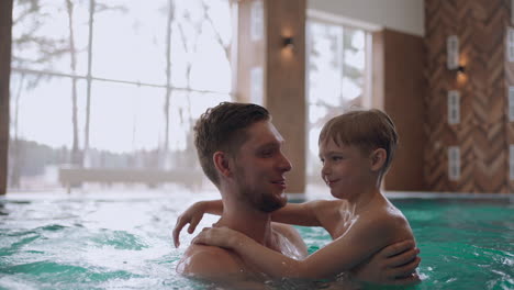 Familien-Wellnesscenter-Für-Kinder-Und-Erwachsene.-Kleiner-Junge-Und-Sein-Vater-Schwimmen-Zusammen-Im-Pool