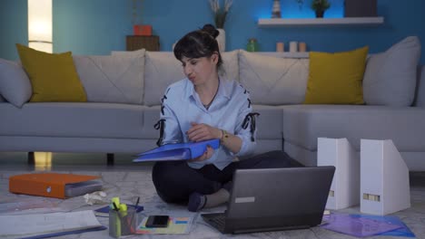 una trabajadora de oficina en casa mirando el archivo con enojo.