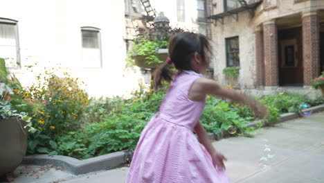 asian girl playing with bubbles in the yard, childhood games in the courtyard