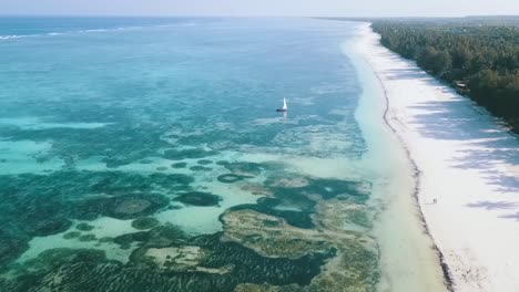 美麗的空中飛行飛向後面 慢慢地沉沒在海岸線上空 無人機射擊 孤獨的帆船在天堂 白沙夢海灘 桑西巴爾非洲