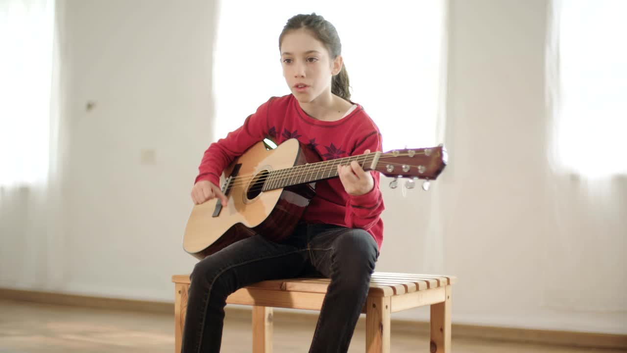 Ung flicka spelar gitarr och sjunger