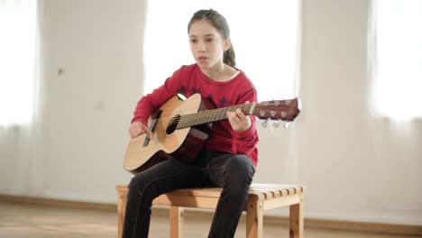 young girl playing guitar and singing