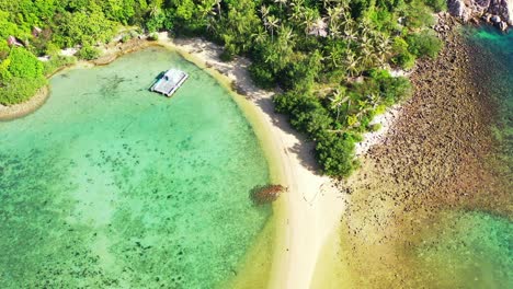 beautiful hidden bay on cape of tropical island with lush vegetation and sandy beach, rocky coastline washed by calm turquoise lagoon in thailand