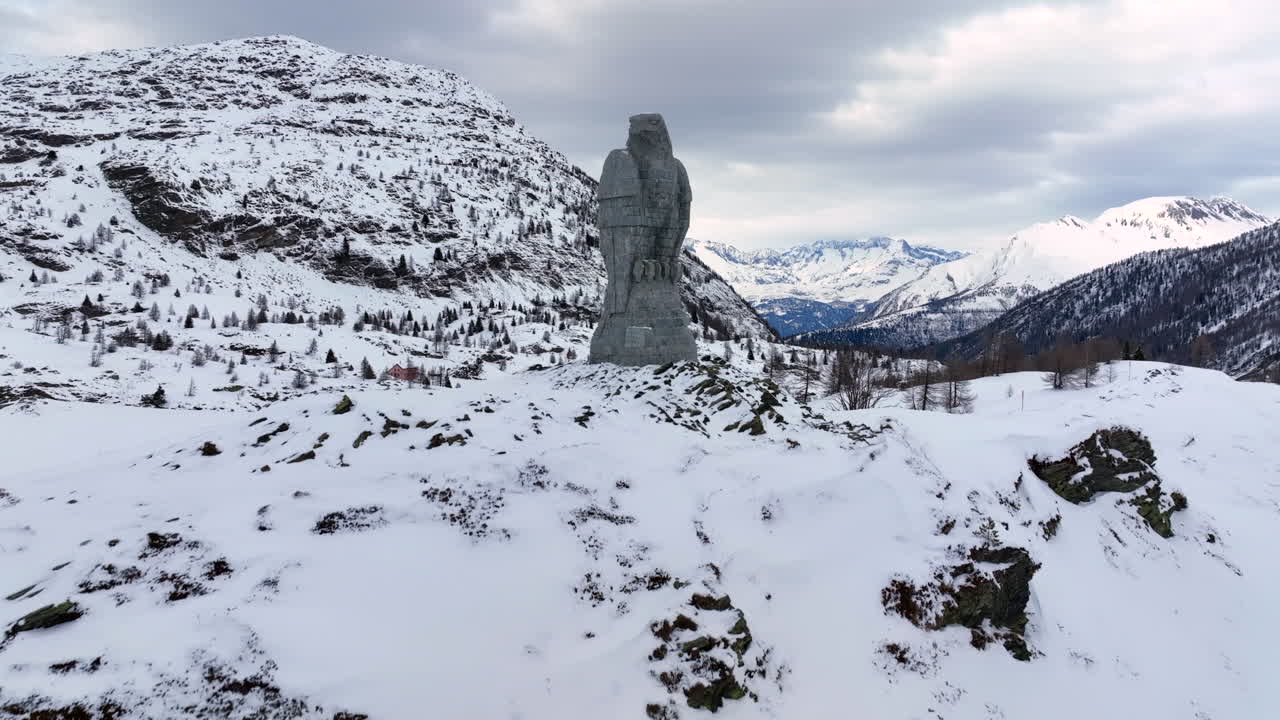 águila escultura de piedra en el paso de simplon con en el fondo los altos alpes suizos cubiertos de nieve