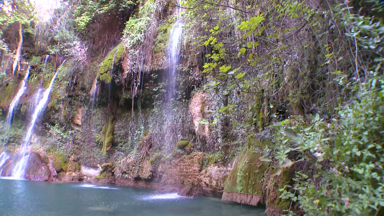 una cascada tropical desemboca en una piscina verde