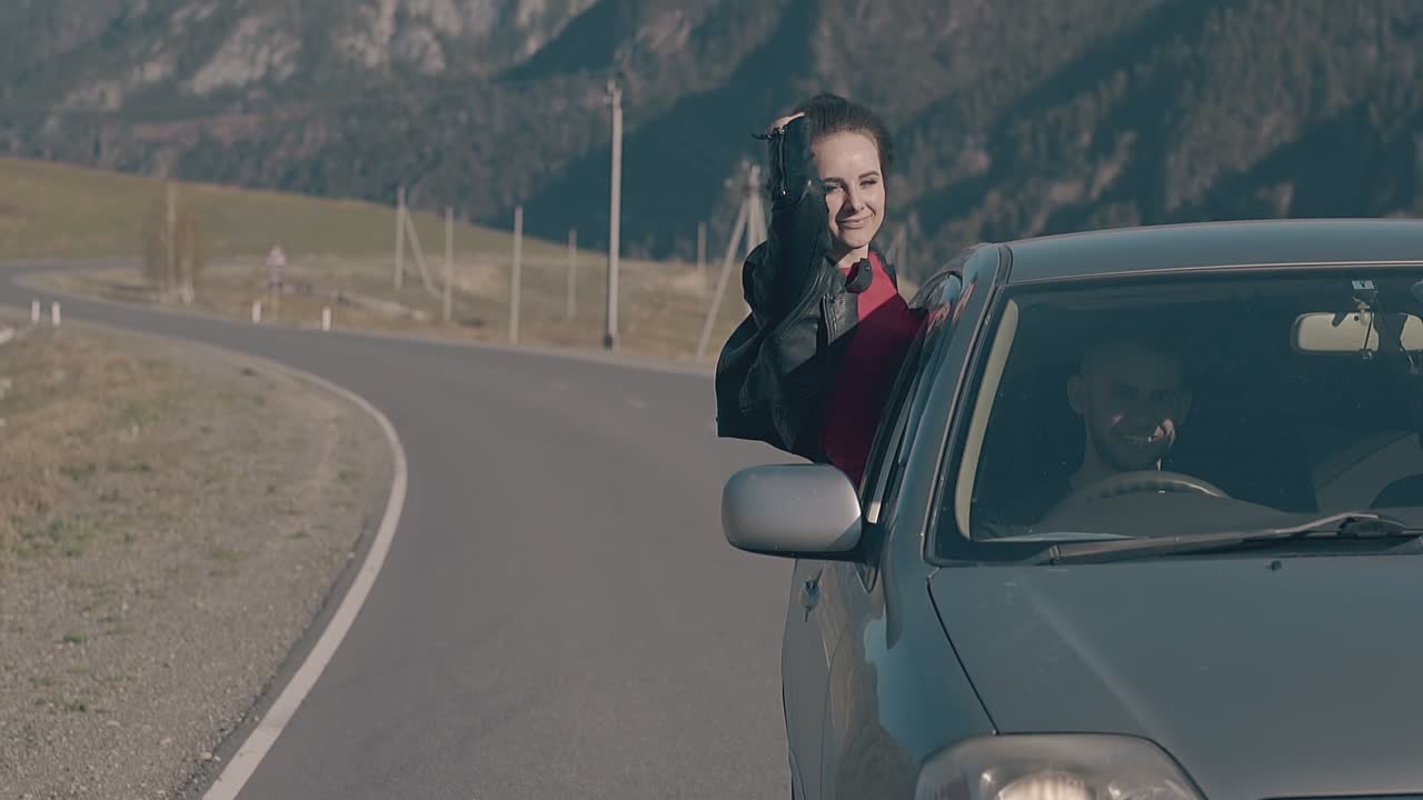 dama de cabello oscuro se siente feliz y relajada sentada en el coche
