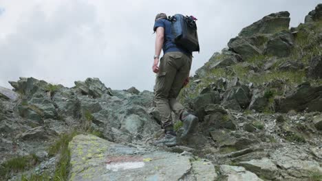 man with backpack on rugged terrain over campagneda hike in valmalenco, sondrio province, lombardy, italy