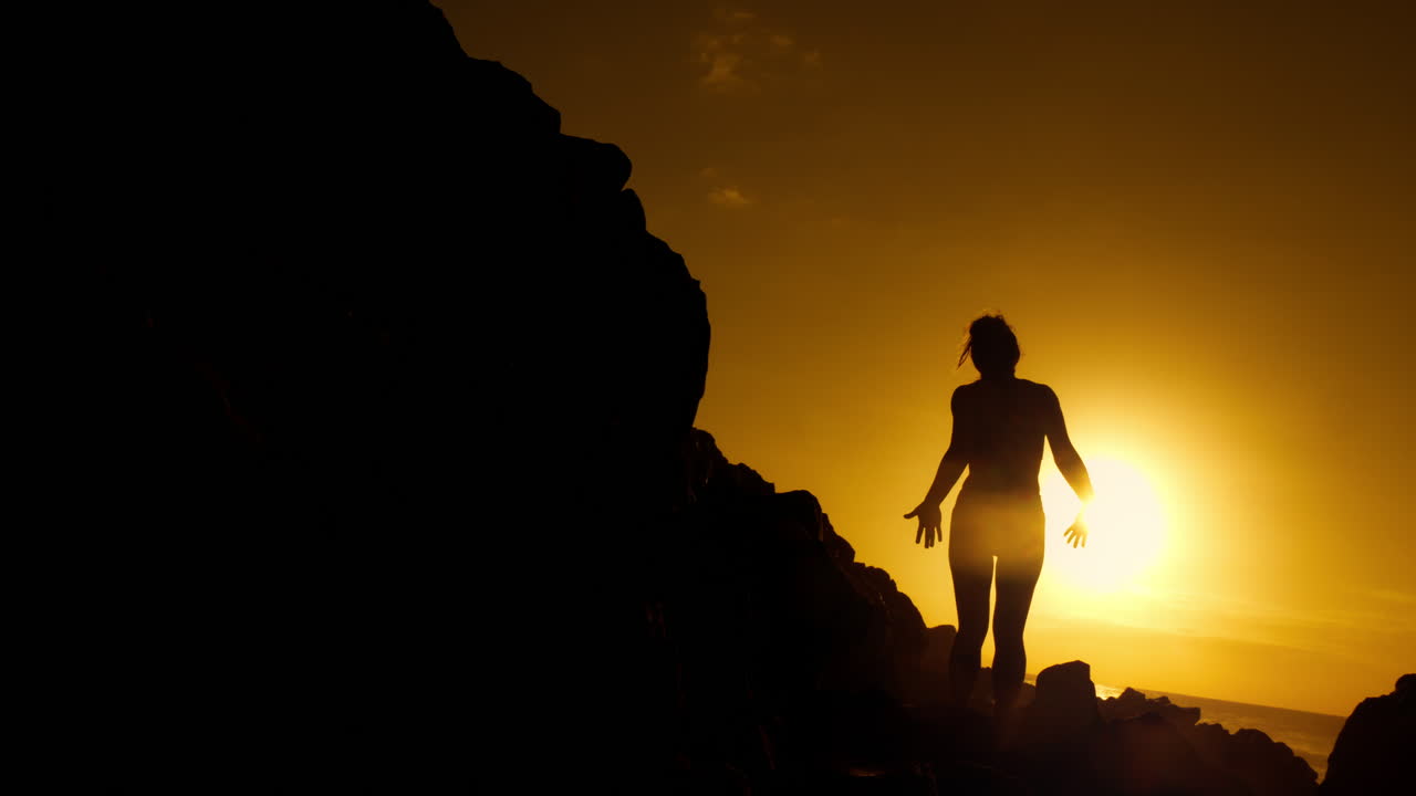 Woman Silhouetted at Sunrise/Sunset on the Coast