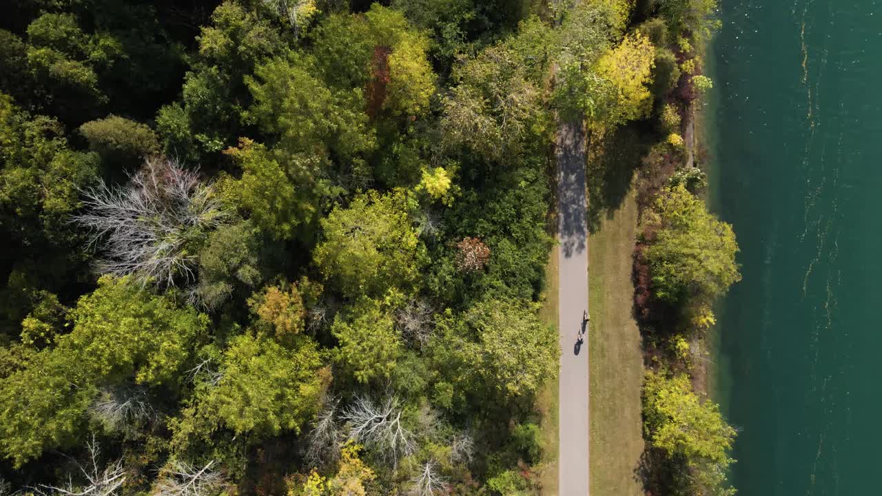 Aerial view of cyclists driving along the river